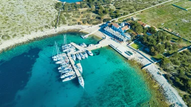 Baia di Zakan Isole Incoronate - Vista aerea con barche a vela ormeggiate in acque turchesi, la fusione perfetta tra strutture moderne e bellezza naturale.