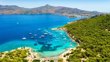 Egina con vista su Monti, è un mosaico di sfumature di blu: le acque cristalline vicino alla riva sfumano in un blu più profondo verso il mare aperto.