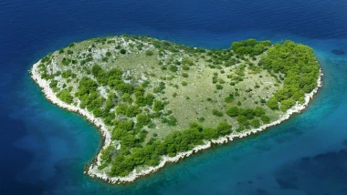 Galesnjak Tra Zara e Biograd: Vista aerea dell'isola, circondata da acque blu intenso e una rigogliosa vegetazione mediterranea.
