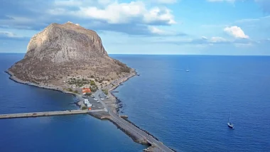 Vista panoramica dall'alto della citta fortificata di Monemvasia del Peloponneso, caratterizzata dalla sua spettacolare posizione su un masso roccioso collegato al continente da un sottile istmo.