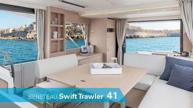 Vista interna del Beneteau Swift Trawler 41 con un ampio salotto e tavolo da pranzo, affacciato sul pittoresco paesaggio costiero.