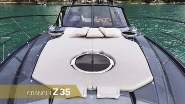 Vista da Prua della Barca a Motore Cranchi Z35 con cuscini per prendere il sole e una vista sulle acque verdi del mare.